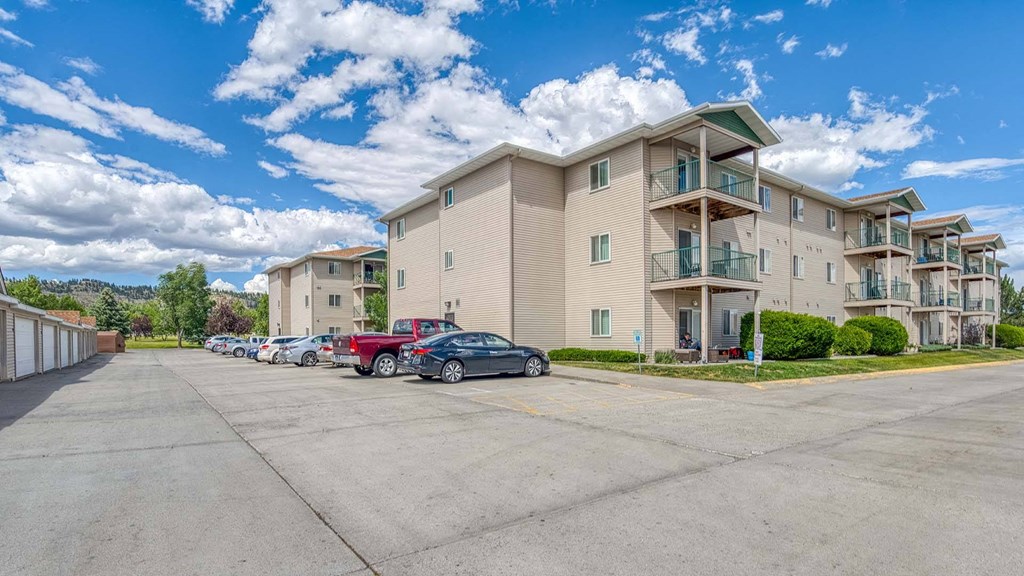 a row of apartment buildings with cars parked in front of them