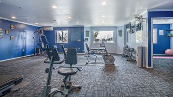 a gym with exercise equipment in a room with blue walls