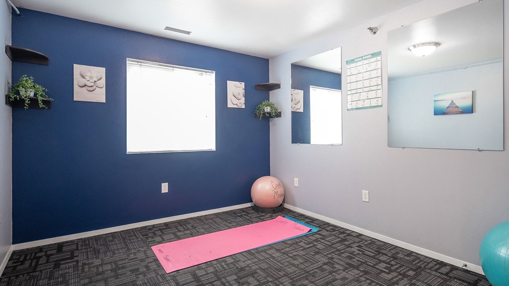 a yoga room with a pink yoga ball and blue walls