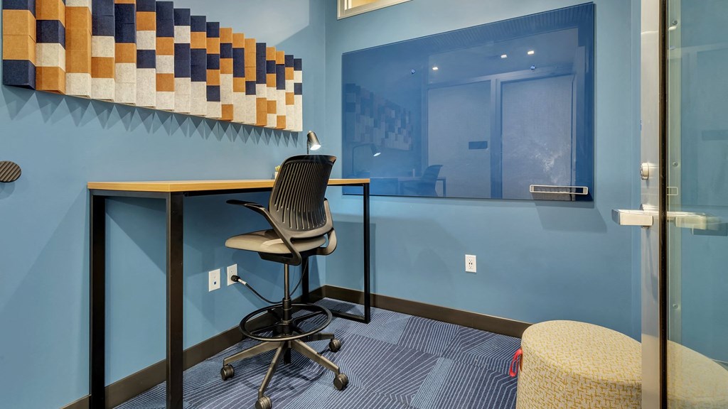 a desk with a chair in a room with a window