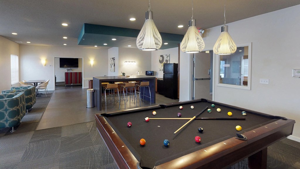 a game room with a pool table and a bar