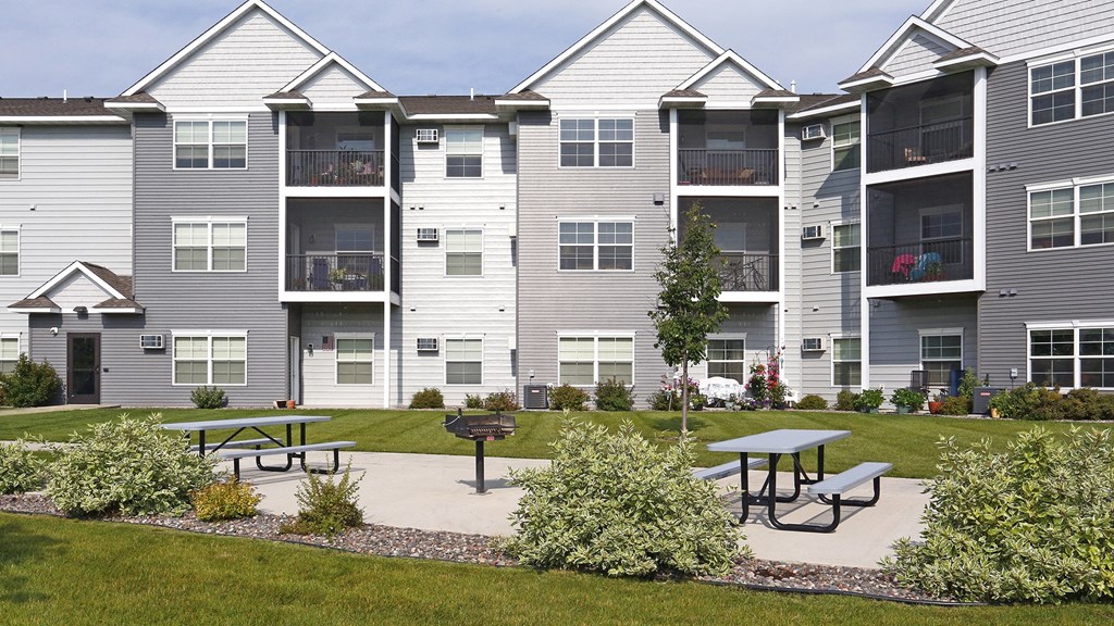 an image of an apartment building with picnic tables