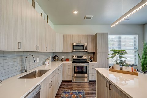 A modern kitchen with wooden cabinets and a white countertop.