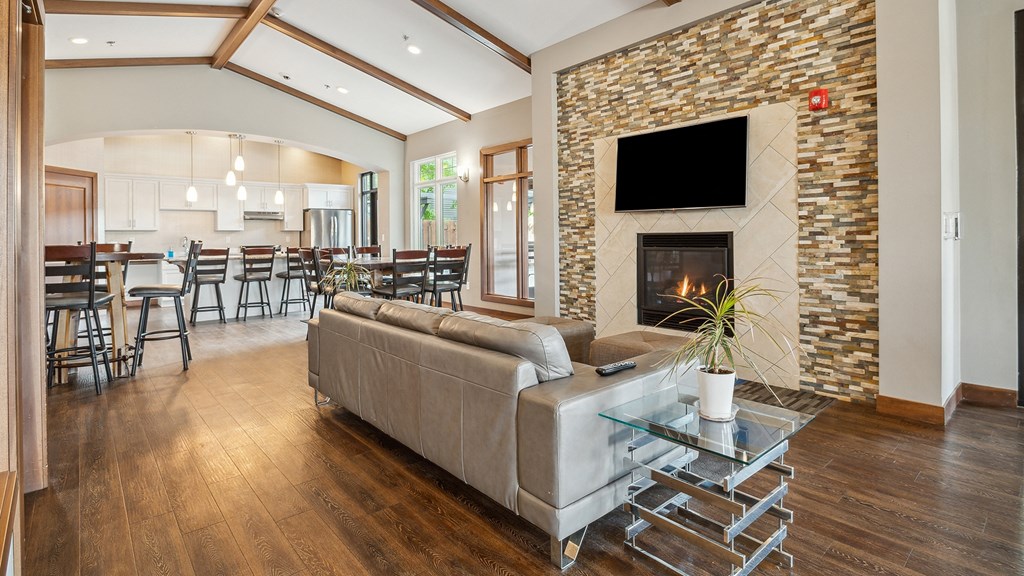 A modern living room with a stone fireplace and a glass coffee table.