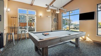 A pool table in a room with a view of the street outside.