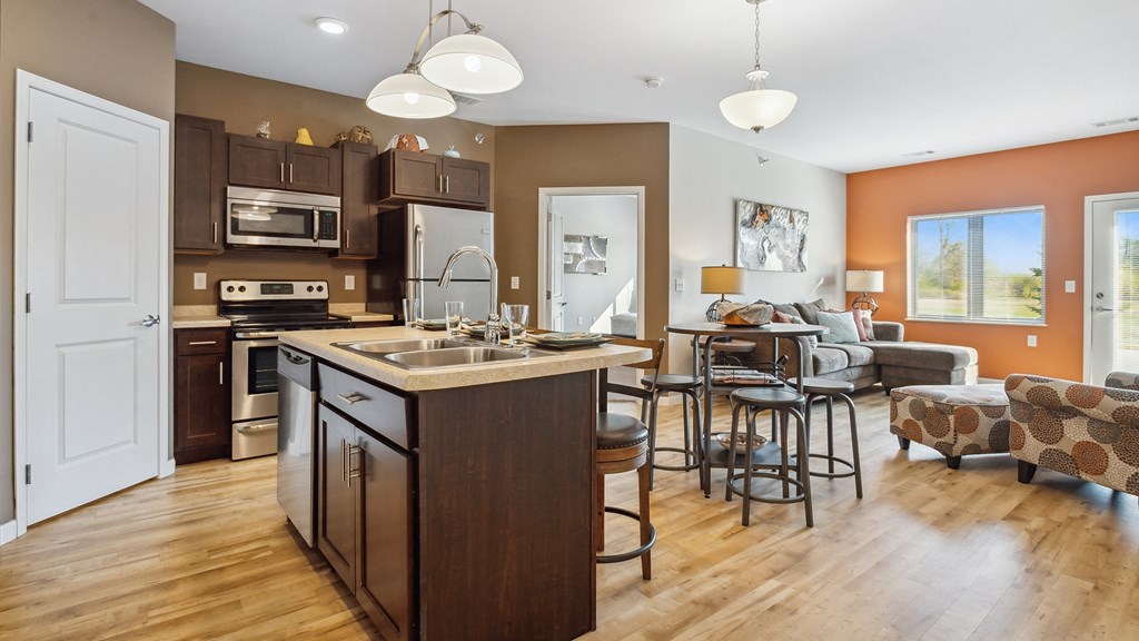 A modern kitchen with a large island and a dining area.