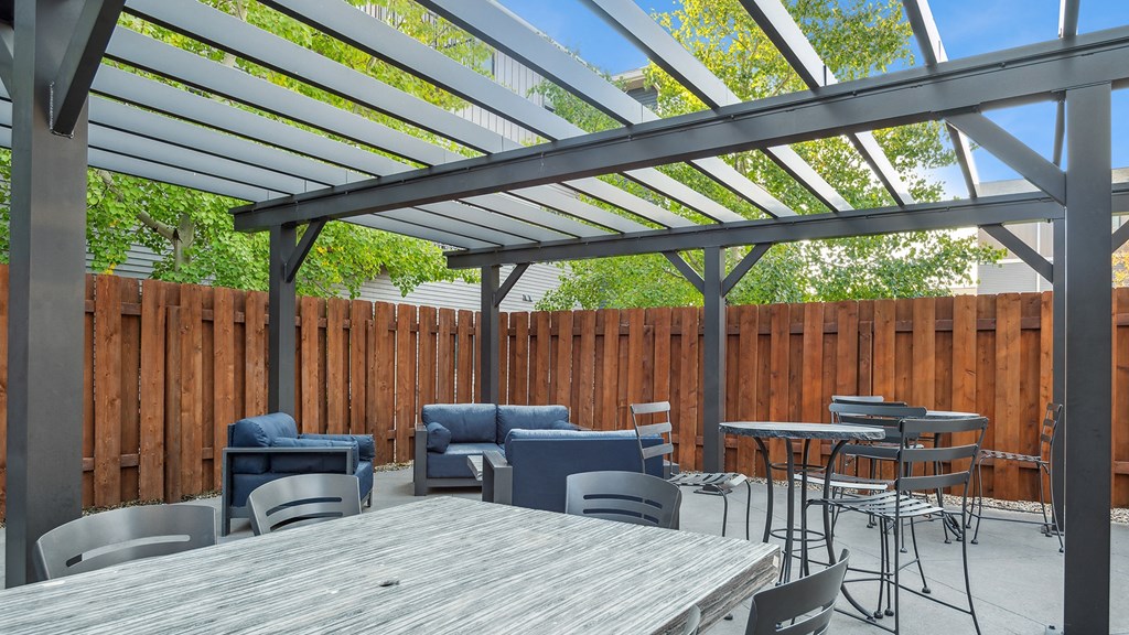 A patio with a table and chairs under a roof.