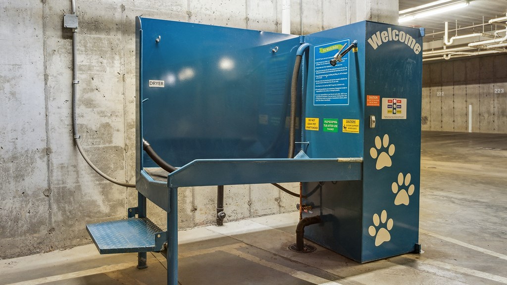 A blue and black dog kennel with a welcome sign and paw prints.