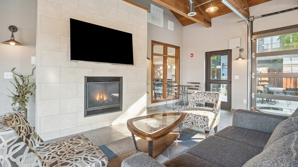 A modern living room with a fireplace and a flat screen TV mounted on the wall.