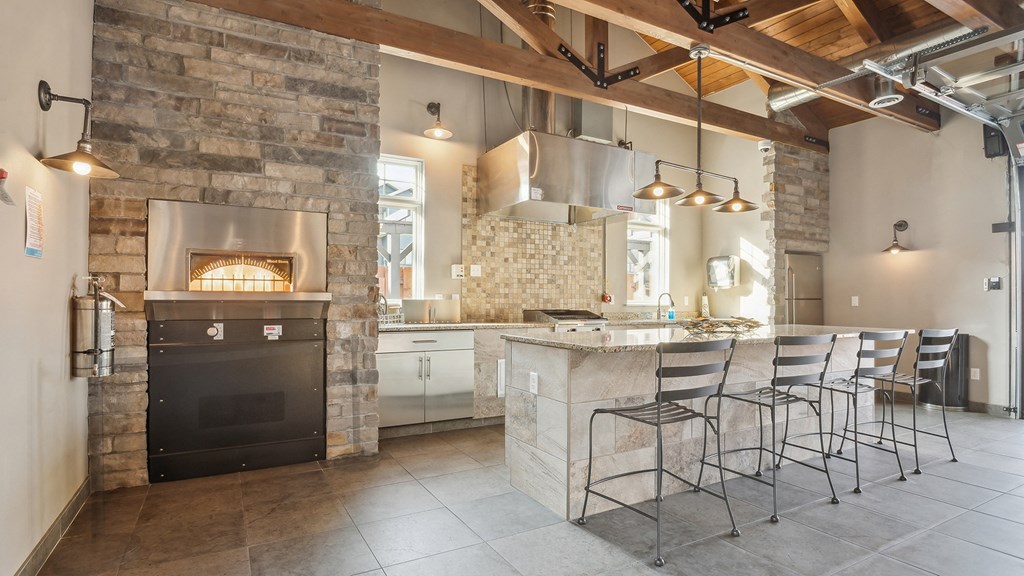 A modern kitchen with a stone fireplace and bar area.