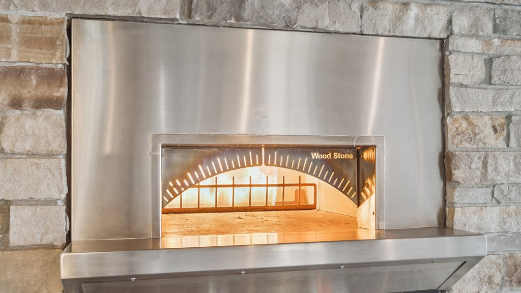 A wood stove with a metal frame and a glass door.