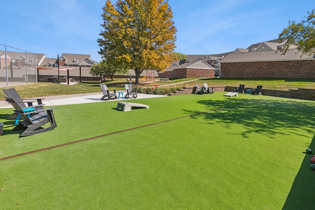 a park with picnic tables and benches on the grass at The Donovan Apartment Homes, Lincoln 68516