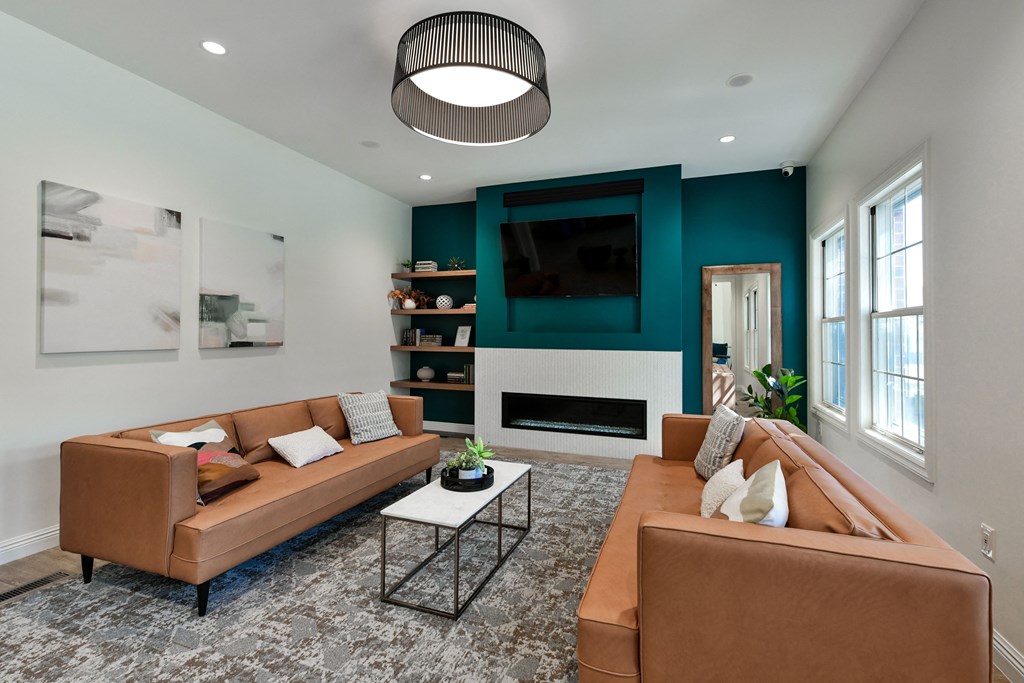 a living room with brown couches and a green accent wall at The Donovan Apartment Homes, Lincoln, NE, 68516
