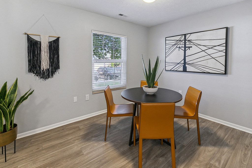 A dining room with a round table and chairs at The Donovan Apartment Homes, Lincoln, Nebraska