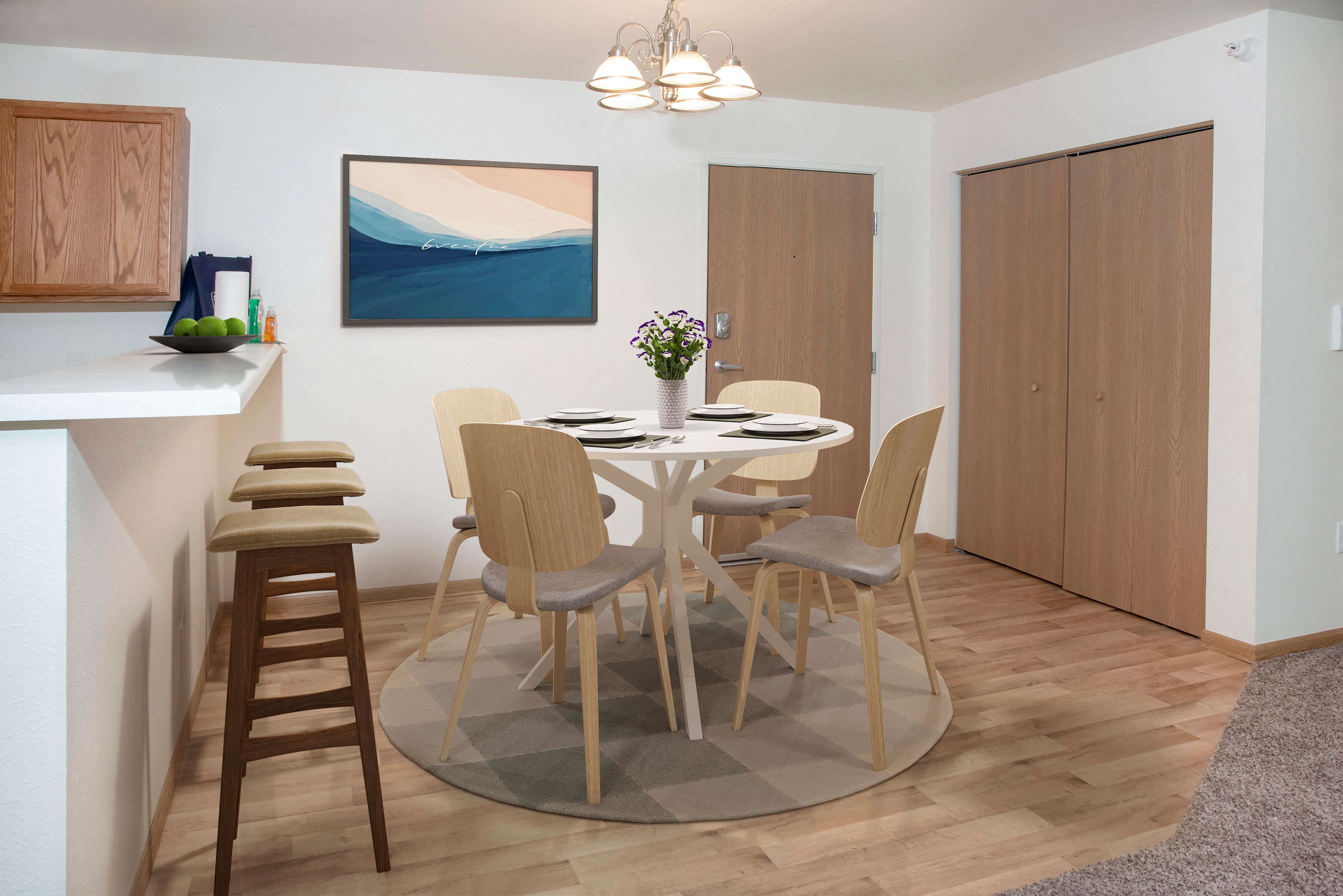 Breakfast bar to seat 3 at island with a separate dining space behind it with coat closets for storage.