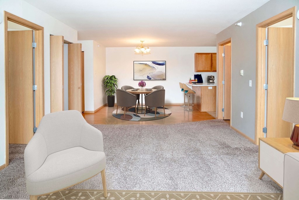 View filled with natural light of open living room looking into dining area and kitchen.
