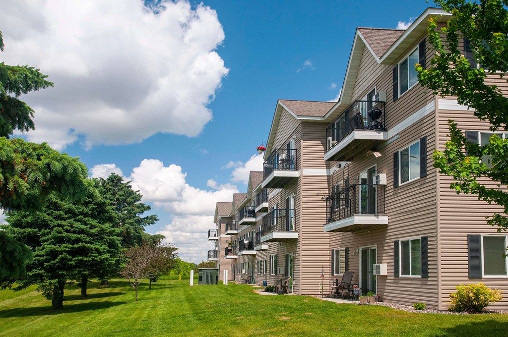 Building exterior of Evergreen Apartments showcasing the lush lawn and large balconies.