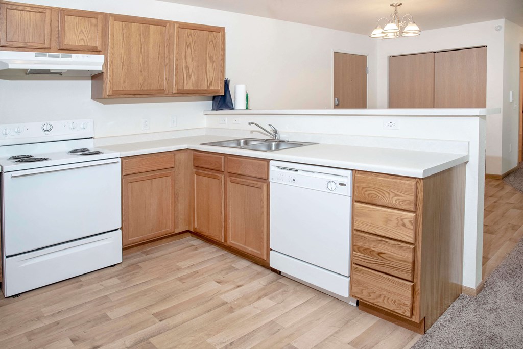 Open kitchen with light faux wood flooring and laminate countertops.