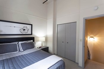 Spacious bedroom with ample closet space and doorway to private bathroom. - Photo Gallery 11