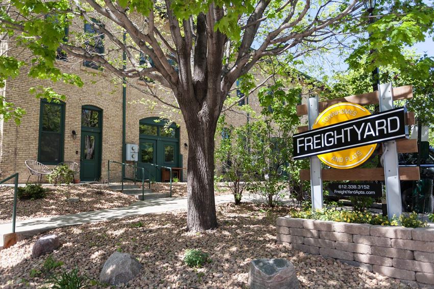 Angled image of FreightYard building exterior of exposed brick with large tree in front. - Photo Gallery 1