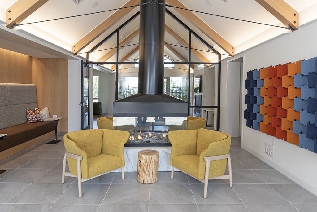 a living room with a fireplace and yellow chairs