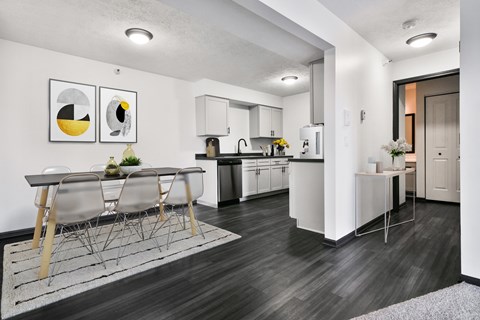 Kitchen and Dining Room with White Cabinets and Dark Hard Wood Flooring