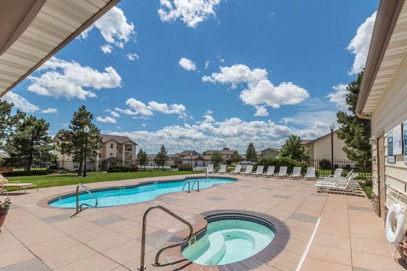 Outdoor resort style fenced in pool and hot tub complete with lounging deck.