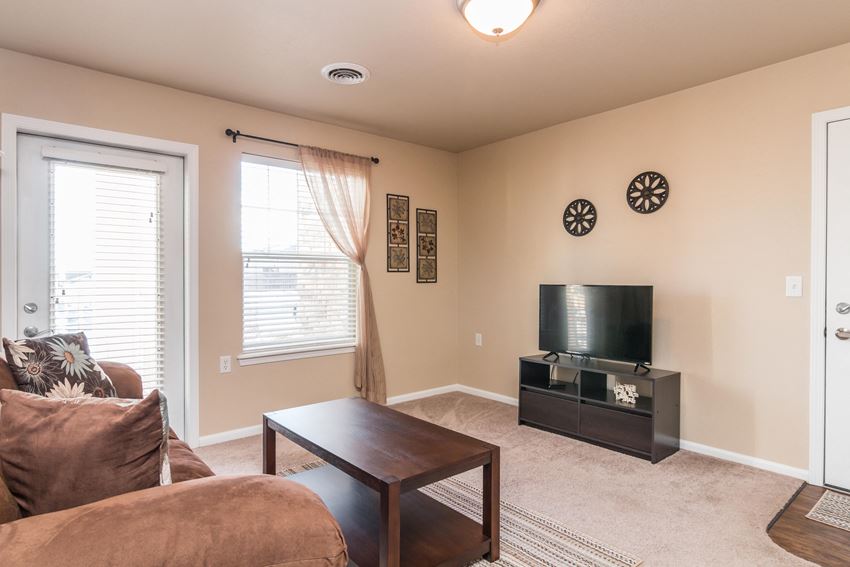 Living room filled with natural light featuring large patio doors by the window. - Photo Gallery