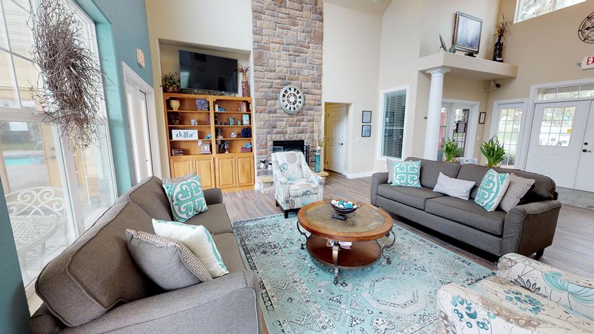 Spacious living area with large windows and a fireplace at Homestead Garden. - Photo Gallery 1