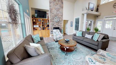 Spacious living area with large windows and a fireplace at Homestead Garden.