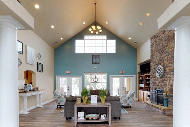 a large living room with a vaulted ceiling and a stone fireplace