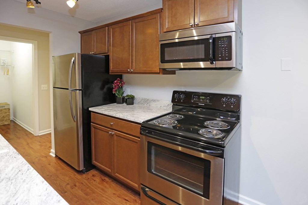 A kitchen with a black stove top oven and a black microwave above it.