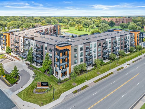 A large apartment complex with a green lawn in front.