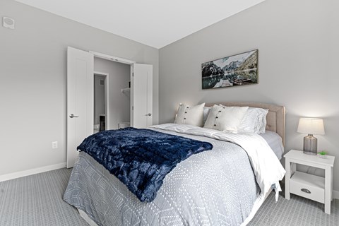 A bedroom with a large bed and a painting on the wall.