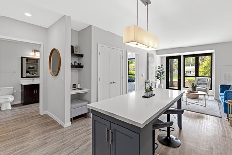 A modern kitchen with a large island and a view of the backyard.