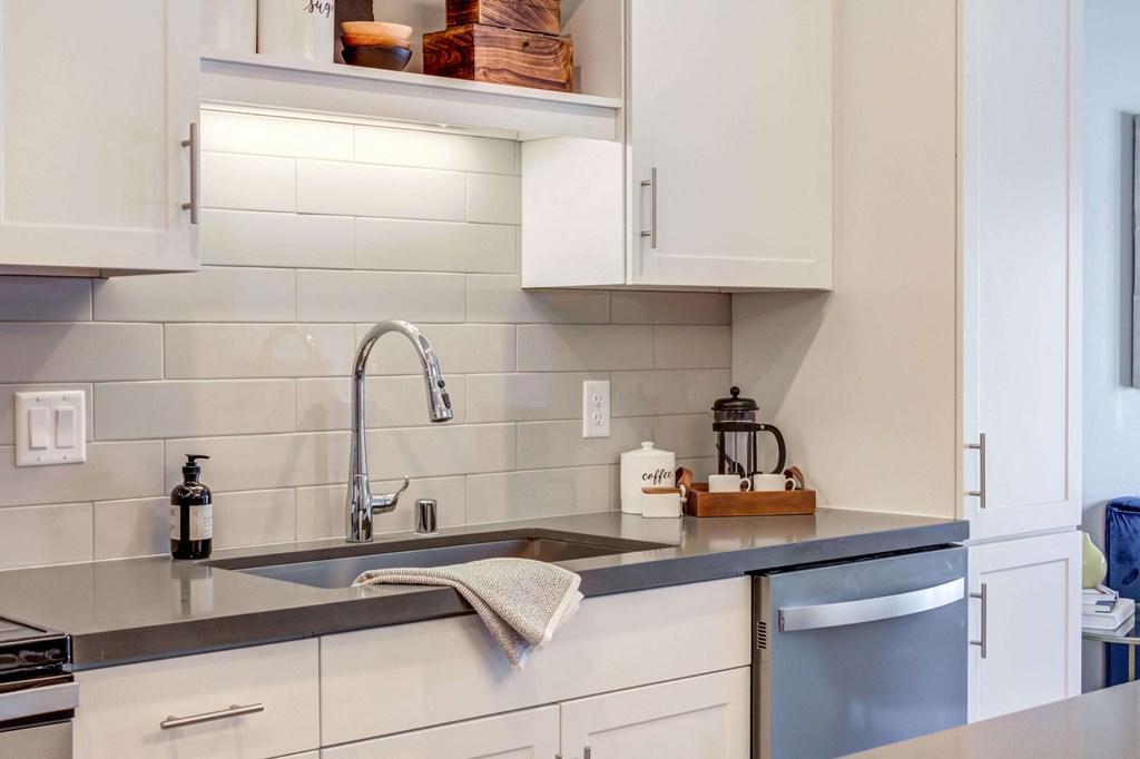 Bright kitchen with white cabinetry and Cesar Stone Quartz countertops.