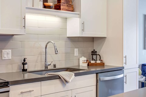 Bright kitchen with white cabinetry and Cesar Stone Quartz countertops.