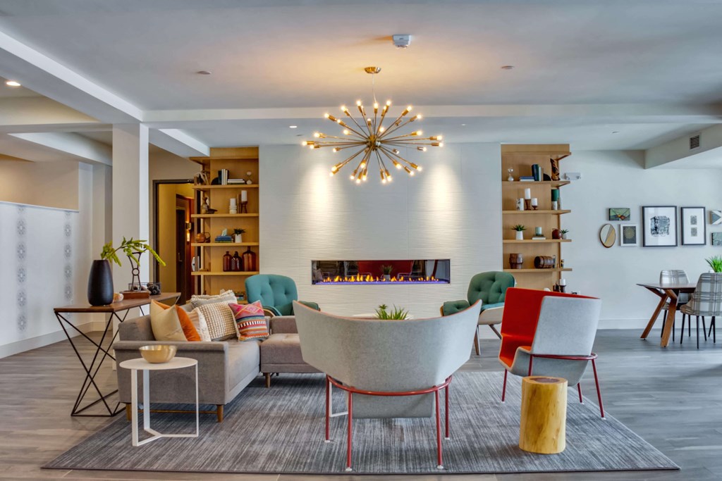 Secondary view of the fireplace lounge area of the community space complete with two large built in bookshelves.
