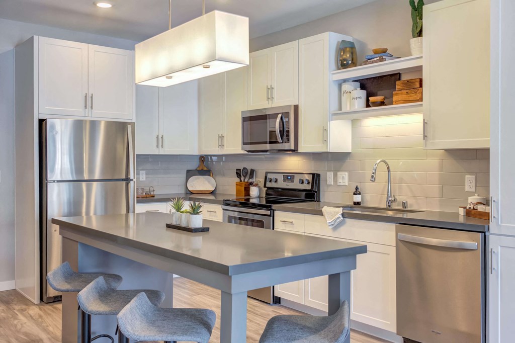 Modern kitchen with bright white cabinetry, stainless steel appliances, and custom kitchen islands.