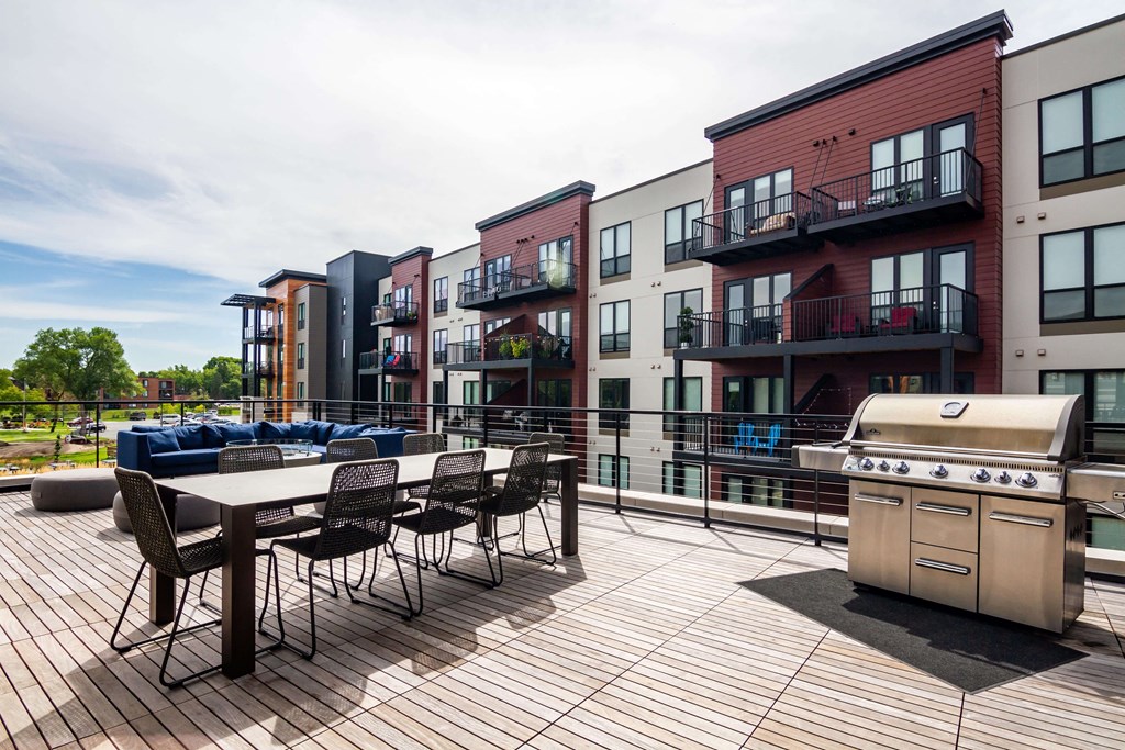 Outdoor deck with large dining table, a grill, and space to entertain.