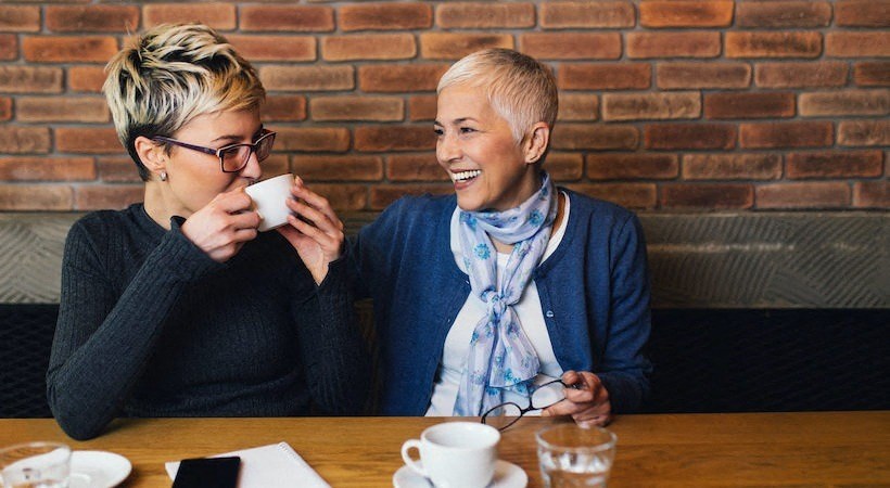 a man and a woman sitting at a table drinking coffee