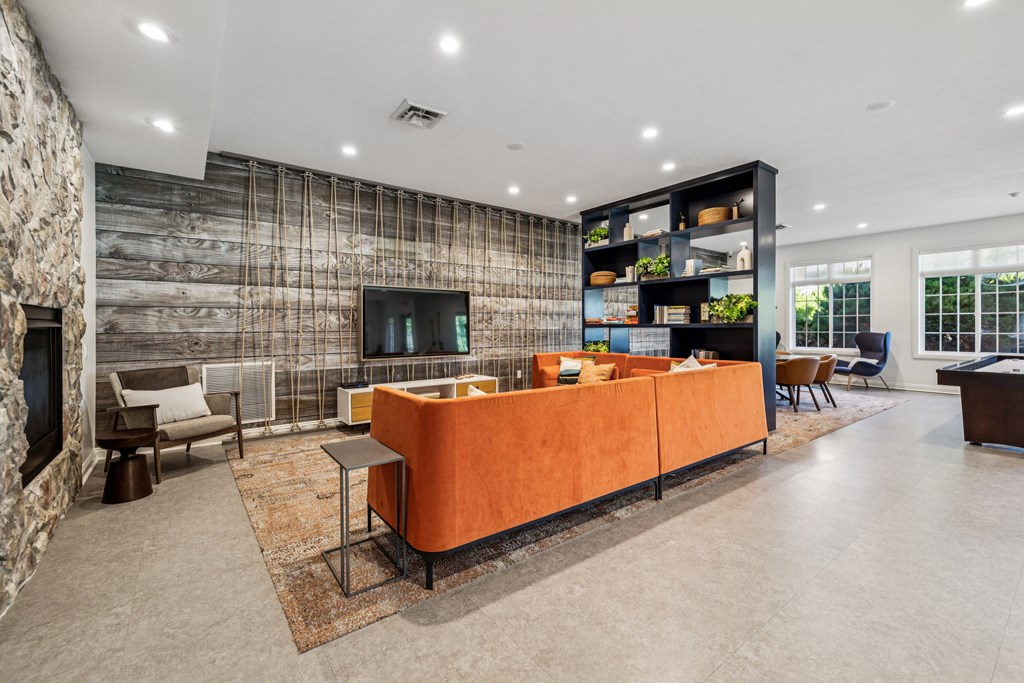 A modern living room with a stone wall and a large orange sofa.