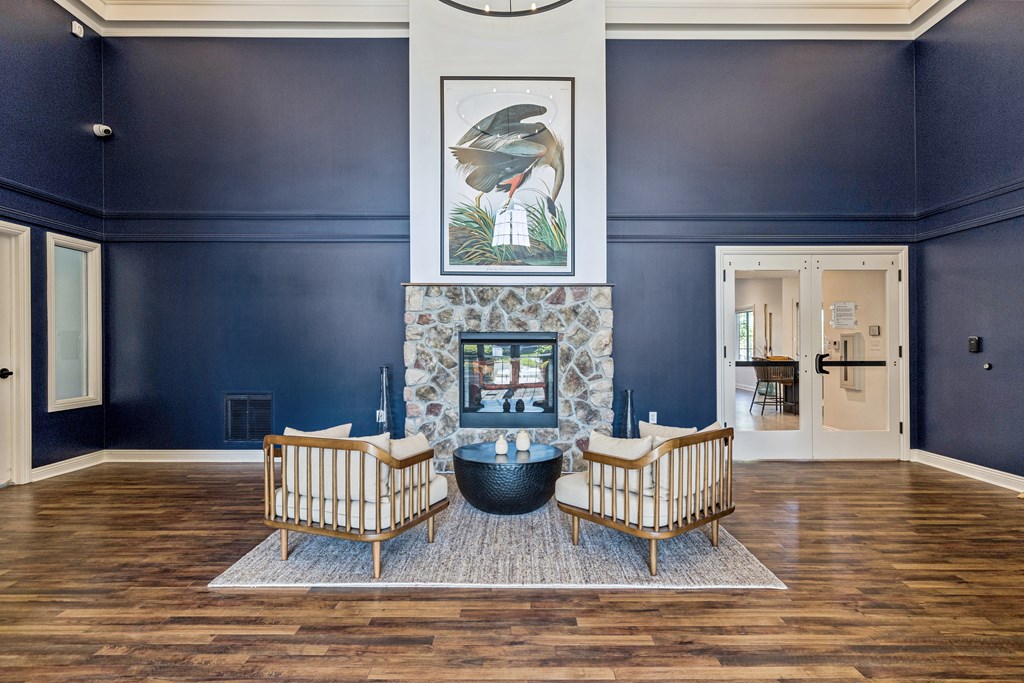 A living room with a fireplace and two chairs.