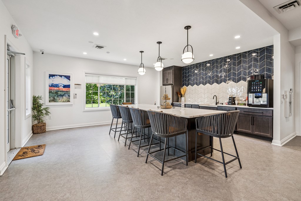 A kitchen with a large island and chairs.