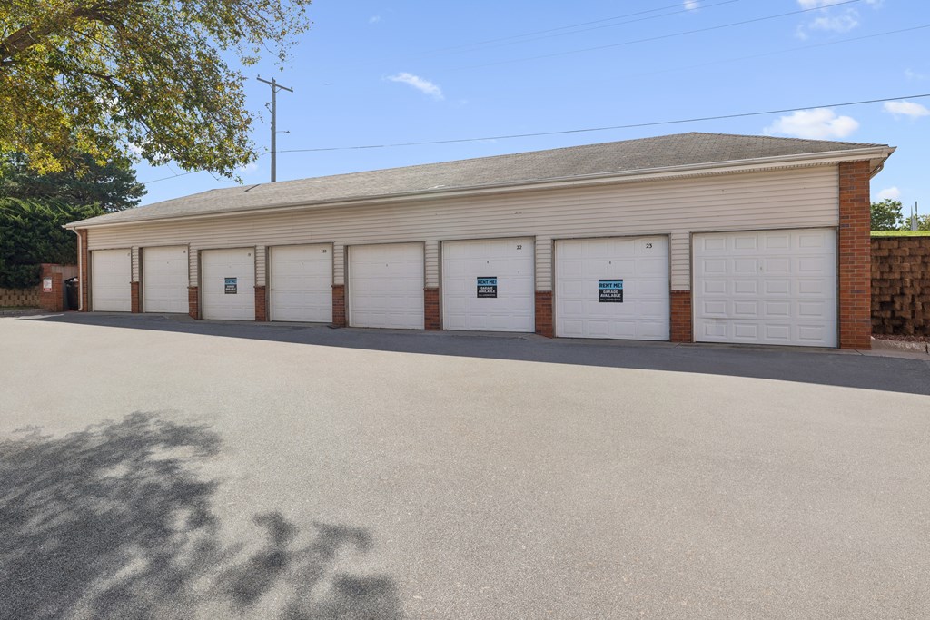 A building with a grey roof and white garage doors.