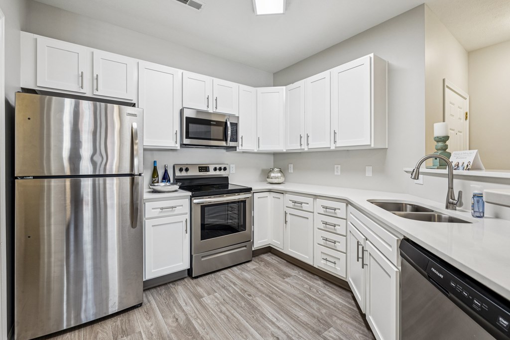 A modern kitchen with white cabinets and stainless steel appliances.