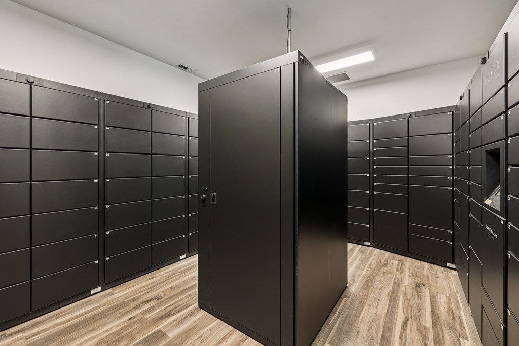 A room with black lockers and a wooden floor.