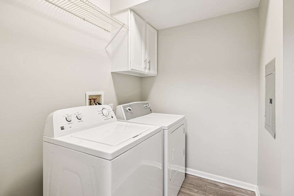A white washing machine and dryer in a small laundry room.