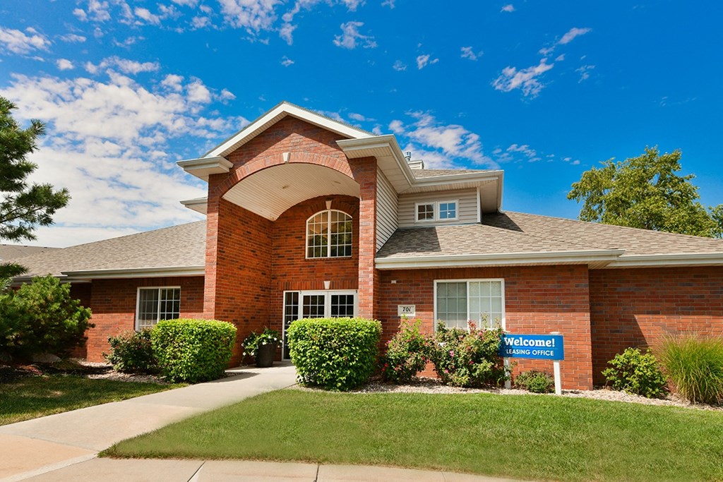 a brick house with a blue sign in front of it