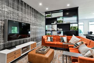 a living room with orange couches and a television